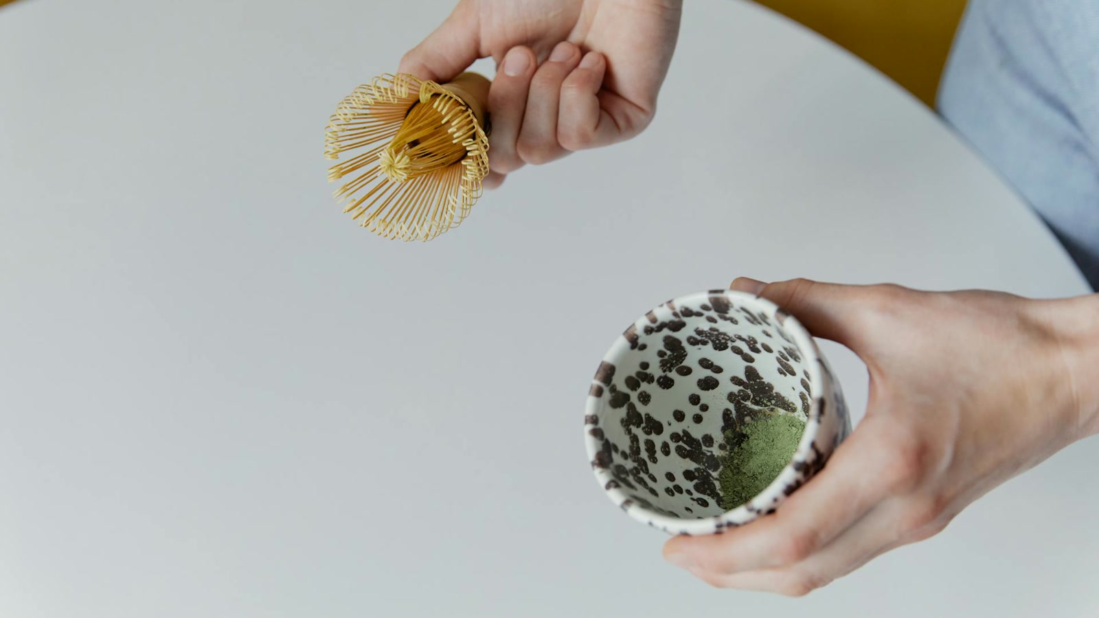 Bamboo matcha whisk (chasen) and ceramic chawan with bright green matcha powder