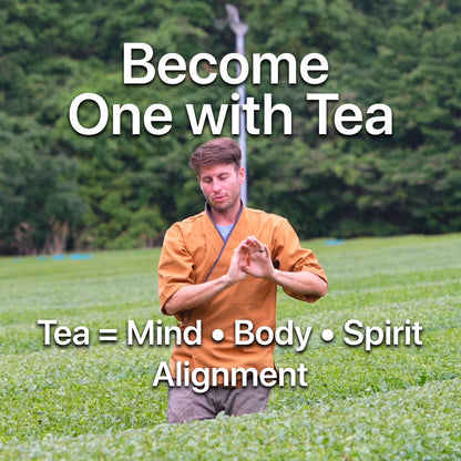 Man in mustard-colored kimono meditating in green tea field, promoting mindfulness with ONE WITH TEA branding.